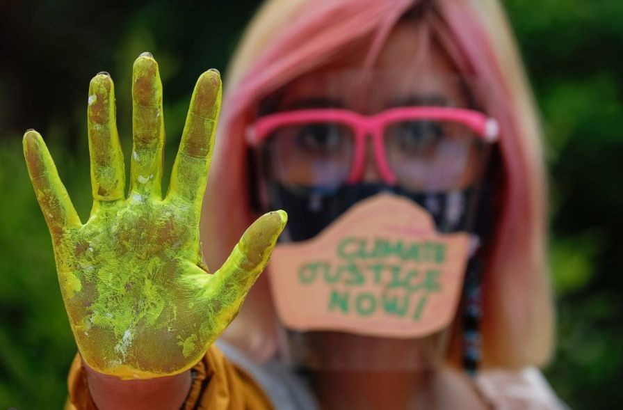 A Filipino climate activist wearing a face shield with the words "Climate Justice Now," poses showing her hand as part of global climate change protests, in Quezon City, Metro Manila, Philippines. REUTERS/Eloisa Lopez